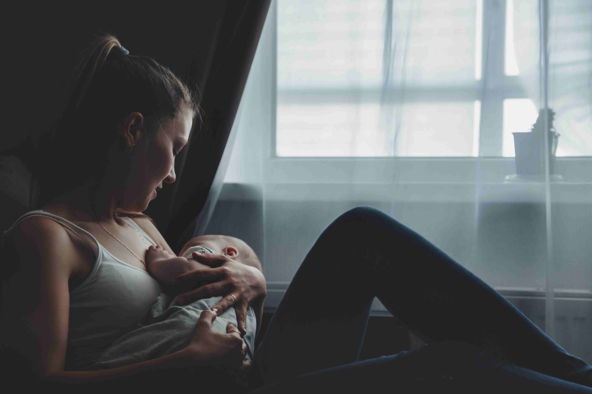 Mother holding her baby at home during the postpartum period
